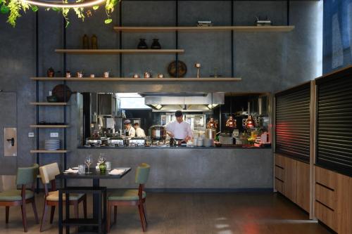 a kitchen with a chef preparing food in a restaurant at Melia Braga Hotel & Spa in Braga