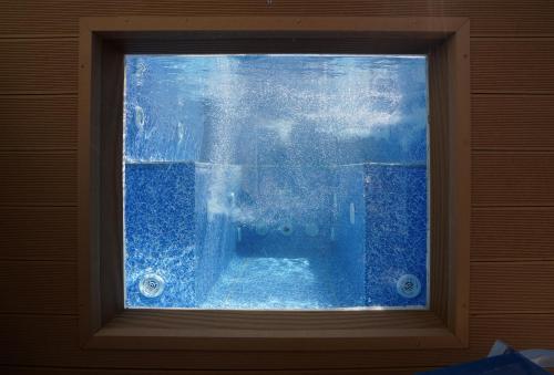 a window with a view of the water through it at SEMIRAMIS SUITES with pool in Kalamata