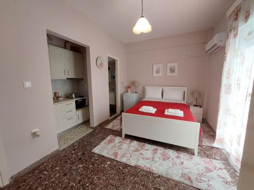 een slaapkamer met een rood en wit bed en een keuken bij Crystal Home near Airport in Artemida