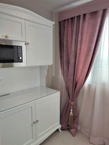 a kitchen with a microwave and a curtain at Light Blue Hotel in Nea Kalikratia