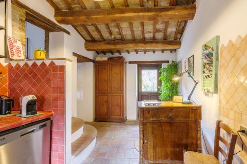 Il comprend une cuisine dotée de plafonds en bois et d'un comptoir. dans l'établissement Un Posto, à Bevagna
