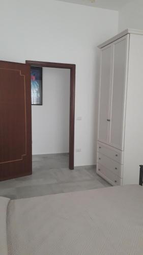 a bedroom with a bed and a closet and a door at Casa sole e luna in Porto Cesareo