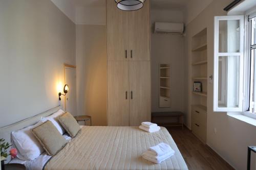 a bedroom with a bed with towels on it at Happiness Aegina Apartments in Aegina Town