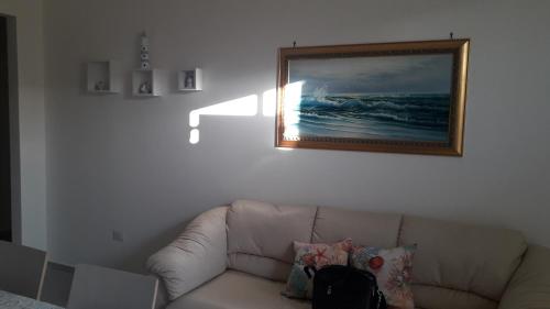 a living room with a couch and a picture on the wall at Casa sole e luna in Porto Cesareo