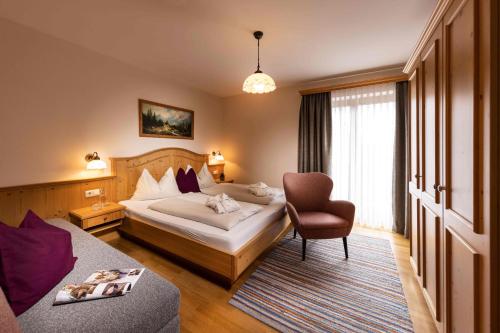 ザンクト・ヴォルフガングにあるLandgasthof Leopoldhofのベッドと椅子付きのホテルルーム