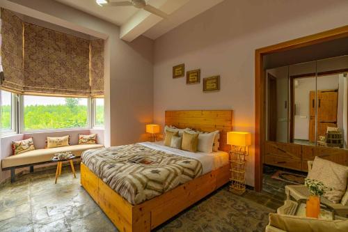 a bedroom with a large bed and a window at StayVista at Peacocks & Partridges with Amidst Greenery, Terrace, Indoor Fireplace, Bar & Snooker Table in Hoshiārpur