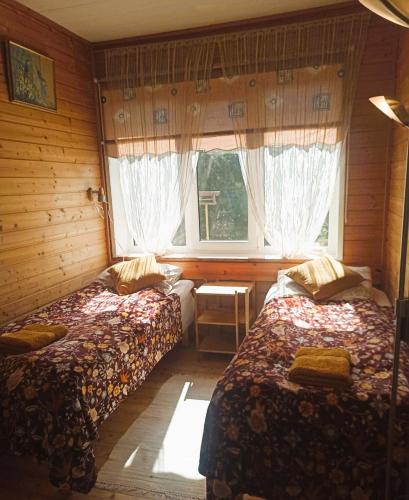 Cette chambre comprend 2 lits et une fenêtre. dans l'établissement Vingi Apartment 12, à Pärnu