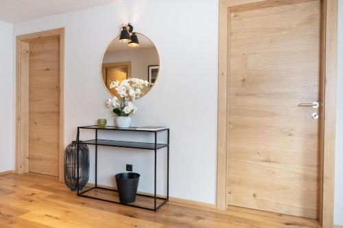 a hallway with a mirror and a table with flowers at Going Living in Going