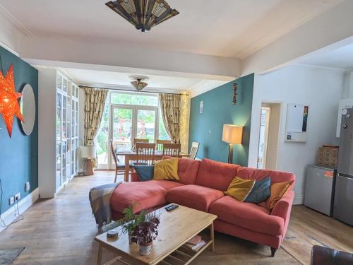 a living room with a red couch and a table at Pass the Keys Spacious Characterful Home in Bournemouth