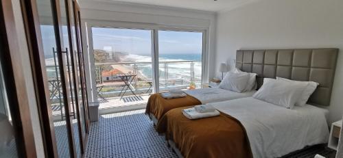 a bedroom with two beds and a view of the ocean at Mega Ocean Magoito - Sintra in Sintra