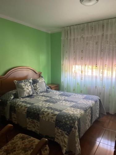 a bedroom with a bed and a window with curtains at Casa Cardin in Cangas de Onís