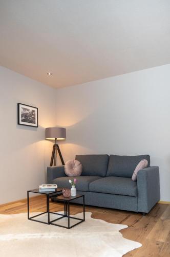 a living room with a blue couch and a table at Going Living in Going