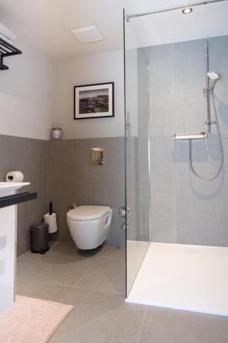 a bathroom with a glass shower and a toilet at Going Living in Going