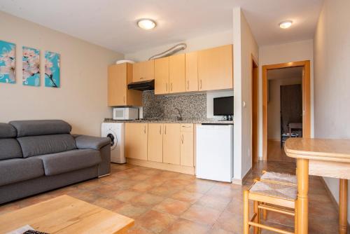a living room with a couch and a kitchen at Apartamentos Aldea del Puente in Cangas de Onís