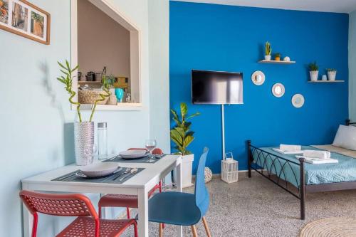 uma sala de estar azul com uma mesa e cadeiras em Blue Suite Manos, in Heraklion em Heraclião