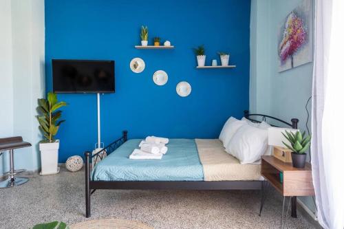 um quarto azul com uma cama com uma parede azul em Blue Suite Manos, in Heraklion em Heraclião