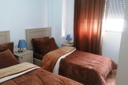 安曼的住宿－Furnished apartment in Jubeiha，酒店客房设有两张床和窗户。