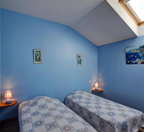 a blue room with two beds and two lamps at Gite Les Cerisiers in Sevelinges