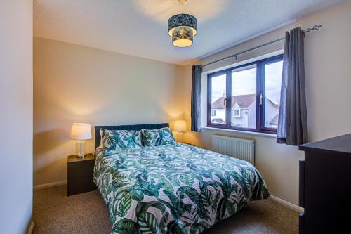 a bedroom with a bed and a large window at Pass the Keys Cosy Home in Chelmsford in Chelmsford