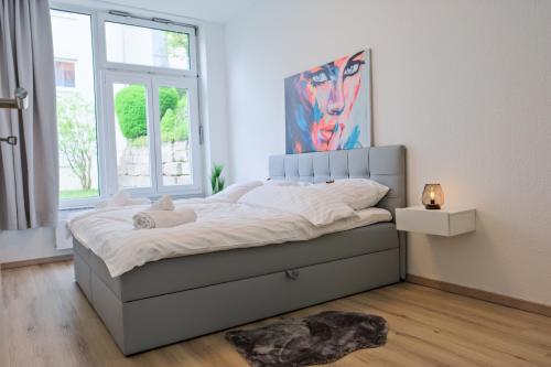 a bedroom with a bed with a painting on the wall at Klassen Apartments! Erleben Sie Aulendorf in dieser modernen Unterkunft in Aulendorf