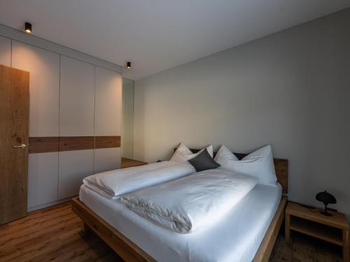 a bedroom with a bed with white sheets at Ferienwohnung Tschuppina Schiess in Brigels