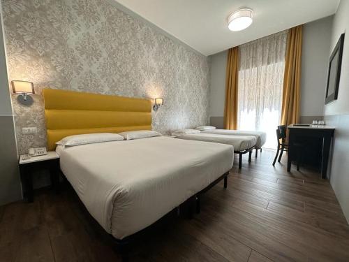 Habitación con 3 camas y cabecero amarillo en Hotel Virgilio, en Roma