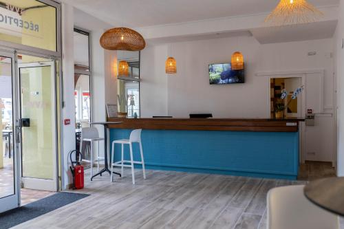 un restaurant avec un bar bleu dans une pièce dans l'établissement VVF Résidence Port-Leucate, à Leucate