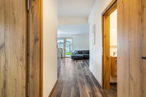 a hallway with wood floors and a living room at Steinwender in Kaltenbach