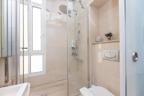 a bathroom with a shower with a toilet and a sink at ApartEasy - Modernist flat in Eixample center in Barcelona
