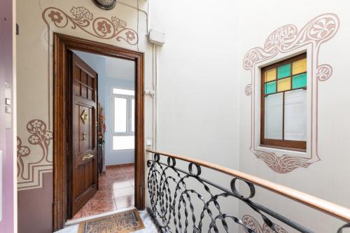 a stairway with a wooden door and a mirror at ApartEasy - Modernist flat in Eixample center in Barcelona
