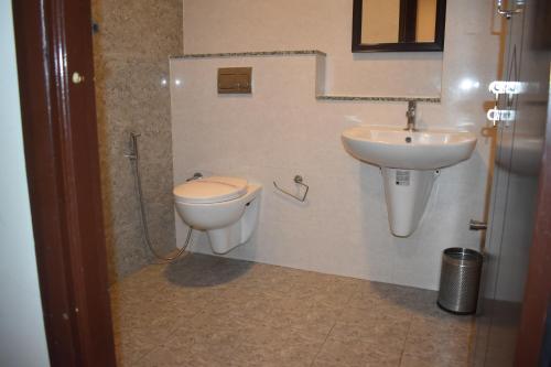 a bathroom with a toilet and a sink at Hotel UR Comforts Jayanagar in Bengaluru