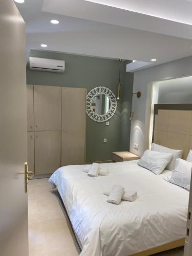 a bedroom with a large white bed with a mirror at Elena Village Hotel & Suites in Kalymnos