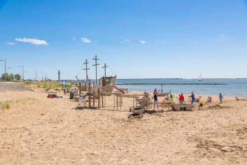 a group of people on a beach near the water at Beachhotel Cape Helius in Hellevoetsluis