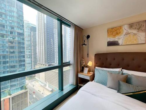 Un pat sau paturi într-o cameră la Angeliz Suites One Uptown Residence 1BR, Book Airport Shuttle, Fast Wifi, FREE Swimming, Across and walk to Uptown Shopping Mall BGC