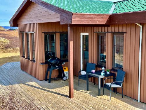 a small house with a table and chairs on a deck at Klettur in Borgarnes