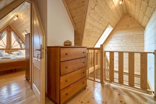 a bedroom with a bed and a dresser in a room at Osada Kościelisko - Tatry na Wyciągnięcie Ręki in Kościelisko