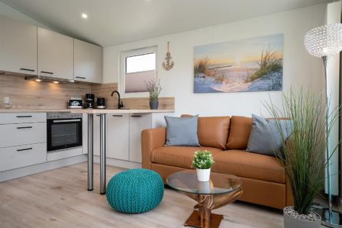 a living room with a couch and a table at Ostseecamp Ferienhaus "StrandPerle" in Scharbeutz