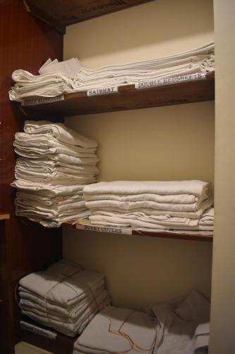 a closet filled with lots of white folded towels at Hotel UR Comforts Jayanagar in Bangalore