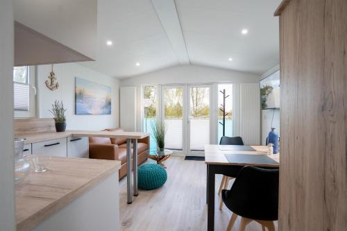 a kitchen with a table and a dining room at Ostseecamp Ferienhaus "StrandPerle" in Scharbeutz