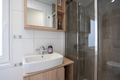 a bathroom with a sink and a shower at Ostseecamp Ferienhaus "StrandPerle" in Scharbeutz