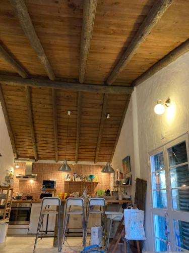 a kitchen with wooden ceilings and tables and chairs at Villa Monte dos Pinheiros in Grândola
