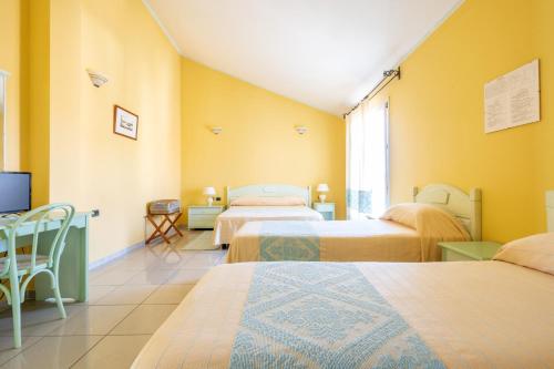 a hotel room with two beds and a tv at Hotel Solki in SantʼAntìoco
