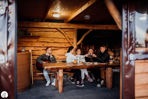 Apartament Pod Górką Gołdap في غوداب: مجموعة من الناس يجلسون على طاولة في مطعم
