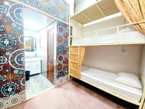 a room with two bunk beds and a bathroom at Colibri Traditional Hostel in Samarkand