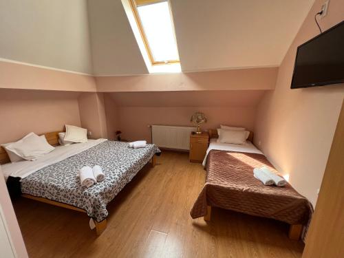 a bedroom with two beds and a window at Motel restoran Sunce in Sremska Kamenica