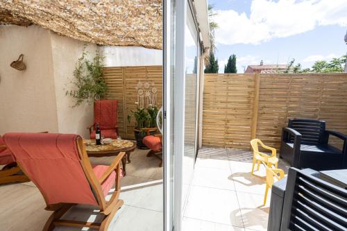 un patio avec une table et des chaises et une clôture dans l'établissement Carnon-Plage, Beach House, à Mauguio