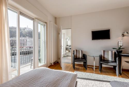 a bedroom with a bed and a desk and chairs at Boutique Hotel KARL in Luzern