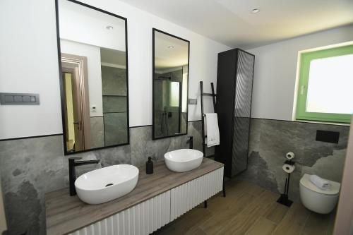 een badkamer met 2 wastafels en 2 spiegels bij VILLA HELENA in Krk