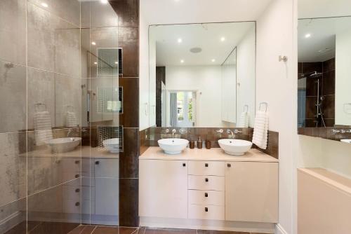 a bathroom with two sinks and a shower at Beautiful Regents Park Apartment in London