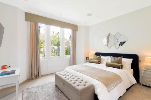 a white bedroom with a large bed and a window at Beautiful Regents Park Apartment in London